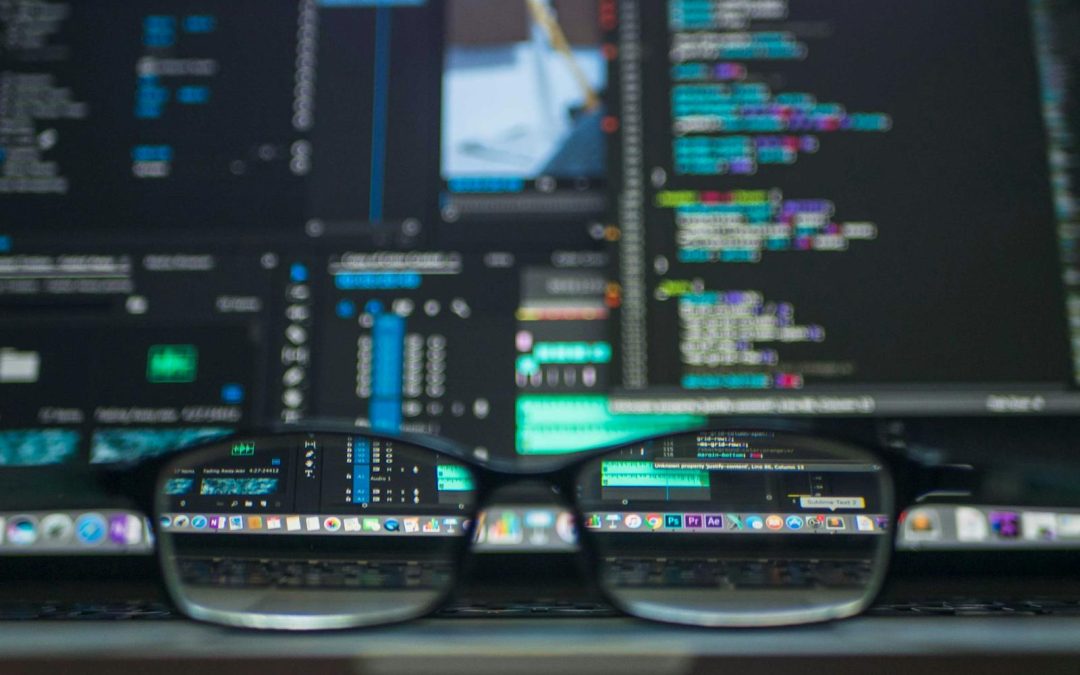 Eyeglasses reflecting computer code on a monitor, ideal for technology and programming themes.